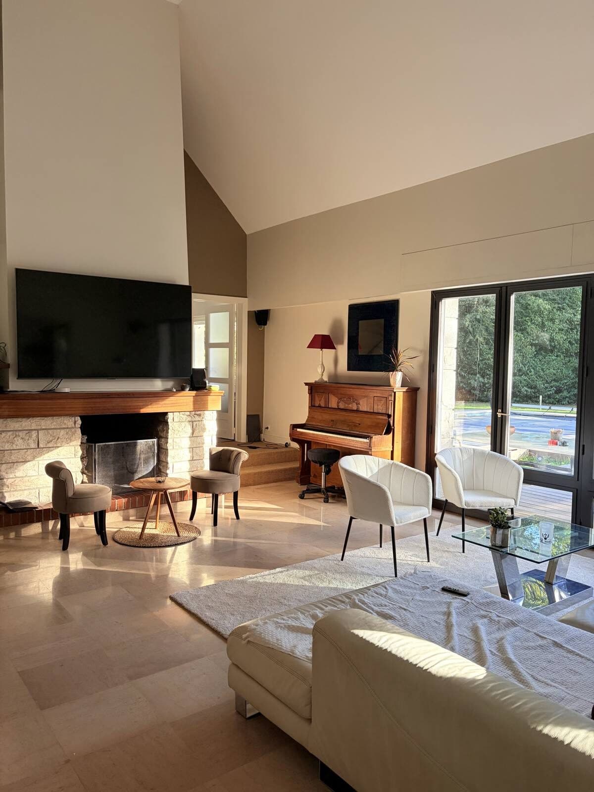 Salon lumineux de la Villa du Bois de Soeuvres, avec cheminée et piano